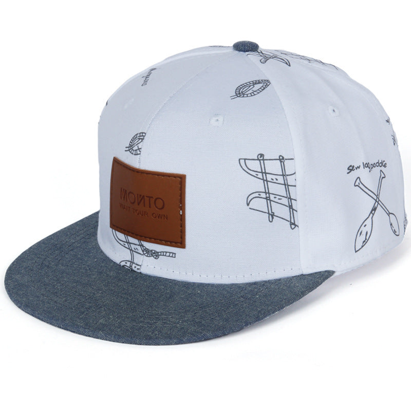 Avslappnad basebollkeps i denim med bokstavspatch och graffititryck.