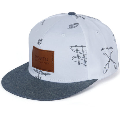 Avslappnad basebollkeps i denim med bokstavspatch och graffititryck.